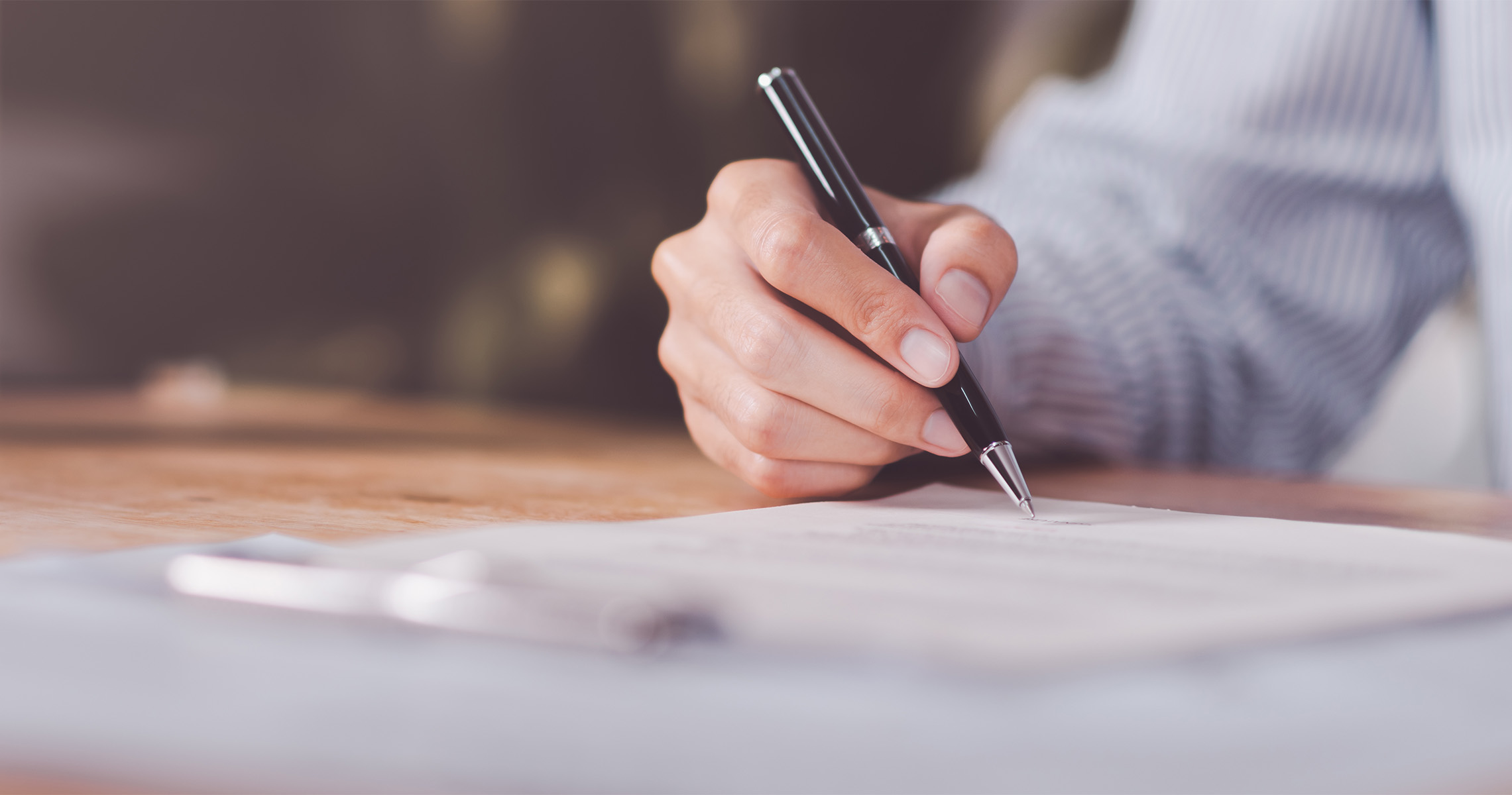 Person writing with a pen