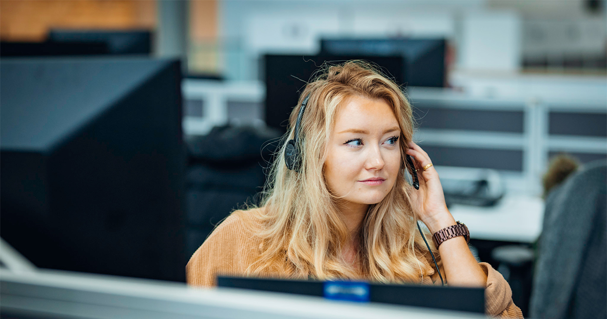 Woman in a call centre answering a call on a headset