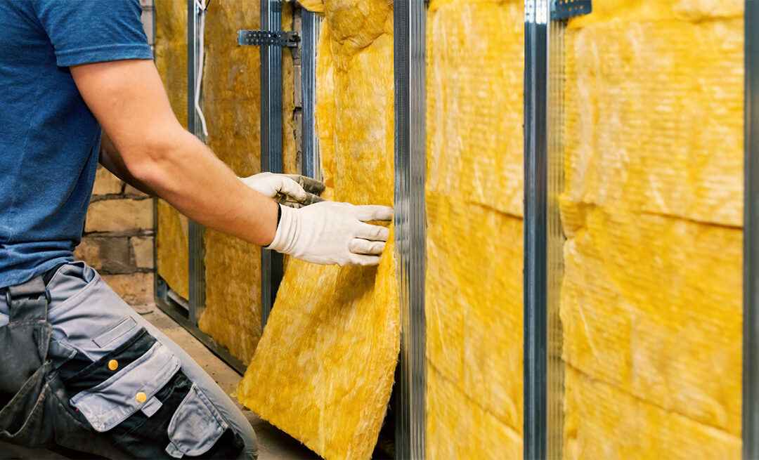Workman placing insulation into wall