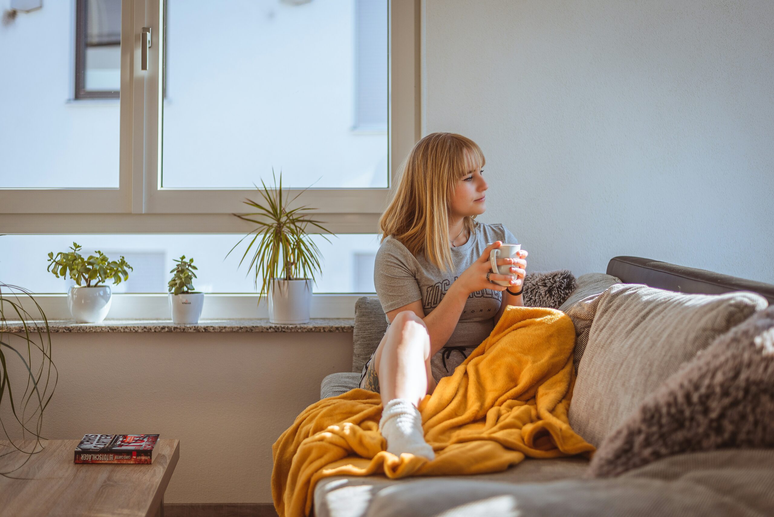 A woman drinking coffee in a warm home