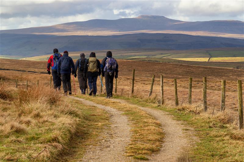 Group of walkers hiking across Dales
